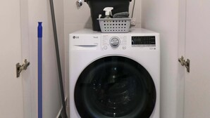 A laundry room with a washing machine, a dryer, and a water heater. - w* | Bright 1BR in Historic Cusco w/ Balcony (Cusco)
