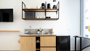 A modern kitchen with wooden cabinets, a built-in microwave, and a black refrigerator. - w *|Grand 2BR w/ Lovely Terrace in Bocagrande (Cartagena de Indias)