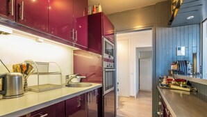 A modern kitchen with stainless steel appliances, a built-in oven, and a microwave. - Panoramic Views from the 17th, by Veeve (Paris)