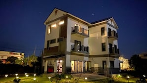 A two-story building with balconies and a well-lit entrance. - Chumentata (Jinsha)