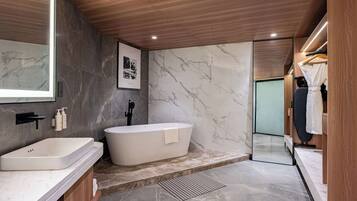 A modern bathroom with a freestanding bathtub, a vanity with a sink, and a large mirror.