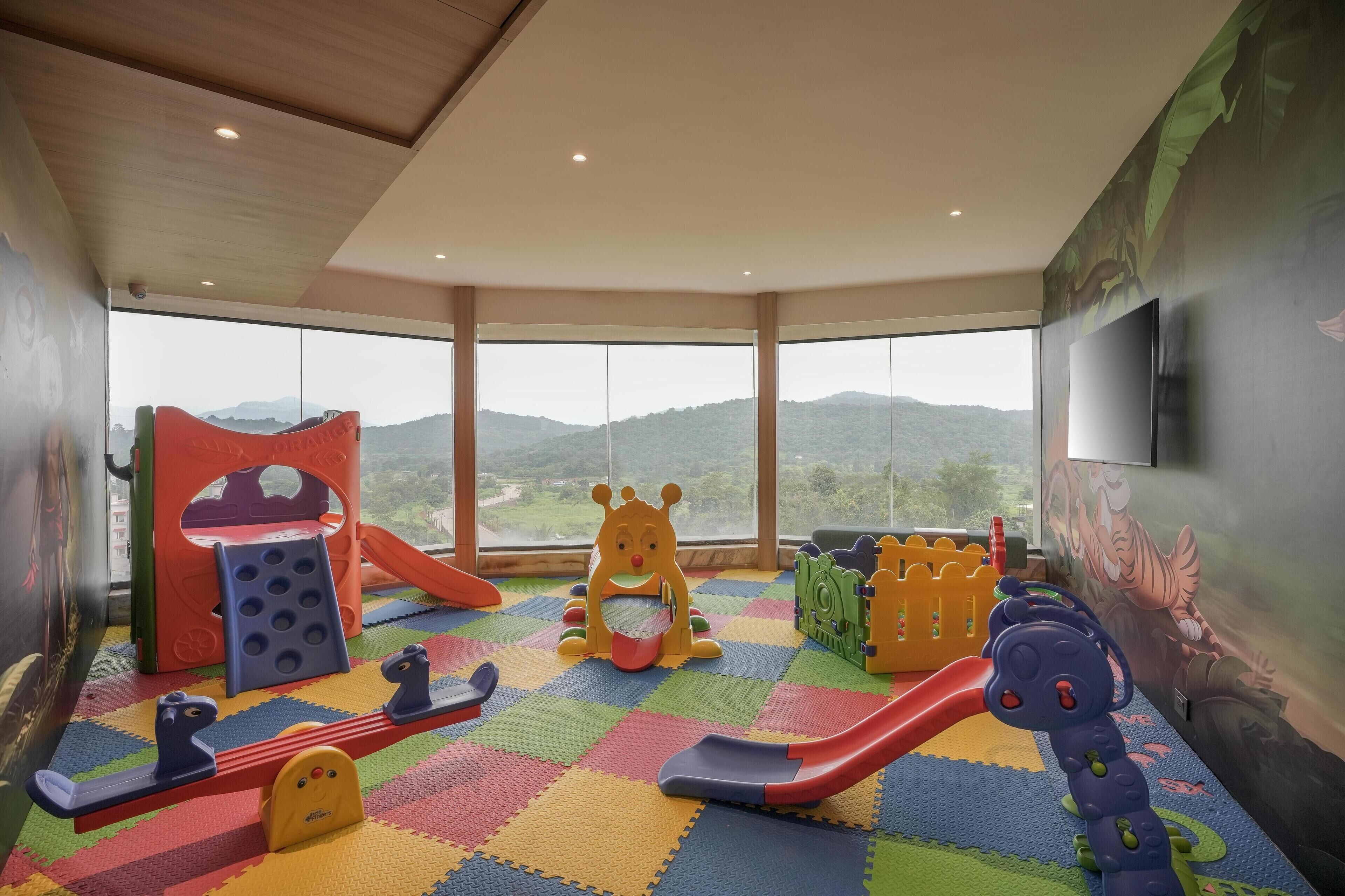 Zona de juegos infantiles con tobogán, estructuras para escalar y un juguete con forma de oso.