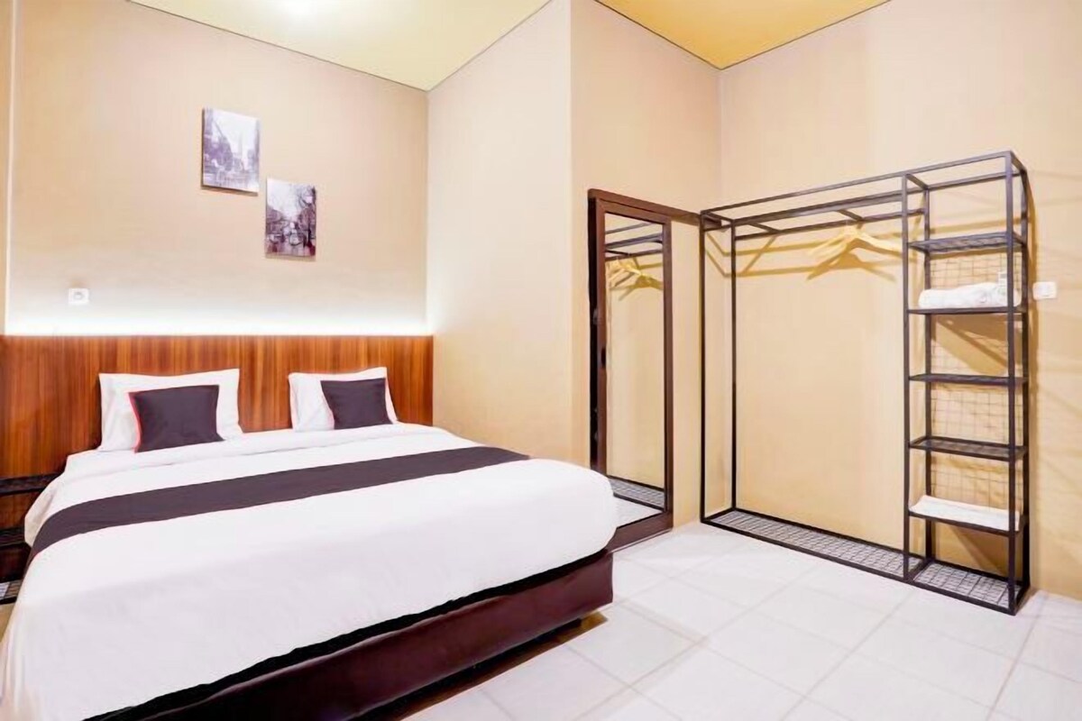 A hotel room with a bed, a wardrobe, and a mirror.