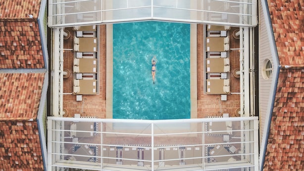 An aerial view of a rooftop pool with a person floating in the center. - Ha(a)ïtza (La Teste-de-Buch)