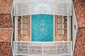 An aerial view of a rooftop pool with a person floating in the center. - Ha(a)ïtza (La Teste-de-Buch)