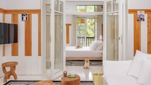 A modern room with a bed, a TV, a wooden stool, and a small table with a cup and saucer. - Ha(a)ïtza (La Teste-de-Buch)