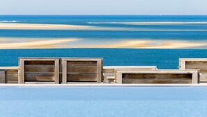 A beach view with wooden deck chairs and a pool. - La Co(o)rniche (La Teste-de-Buch)