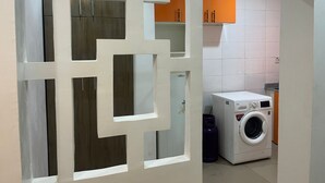 Un cuarto de lavado con lavadora y armarios.