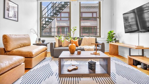 A modern living room with a sofa, coffee table, and TV.