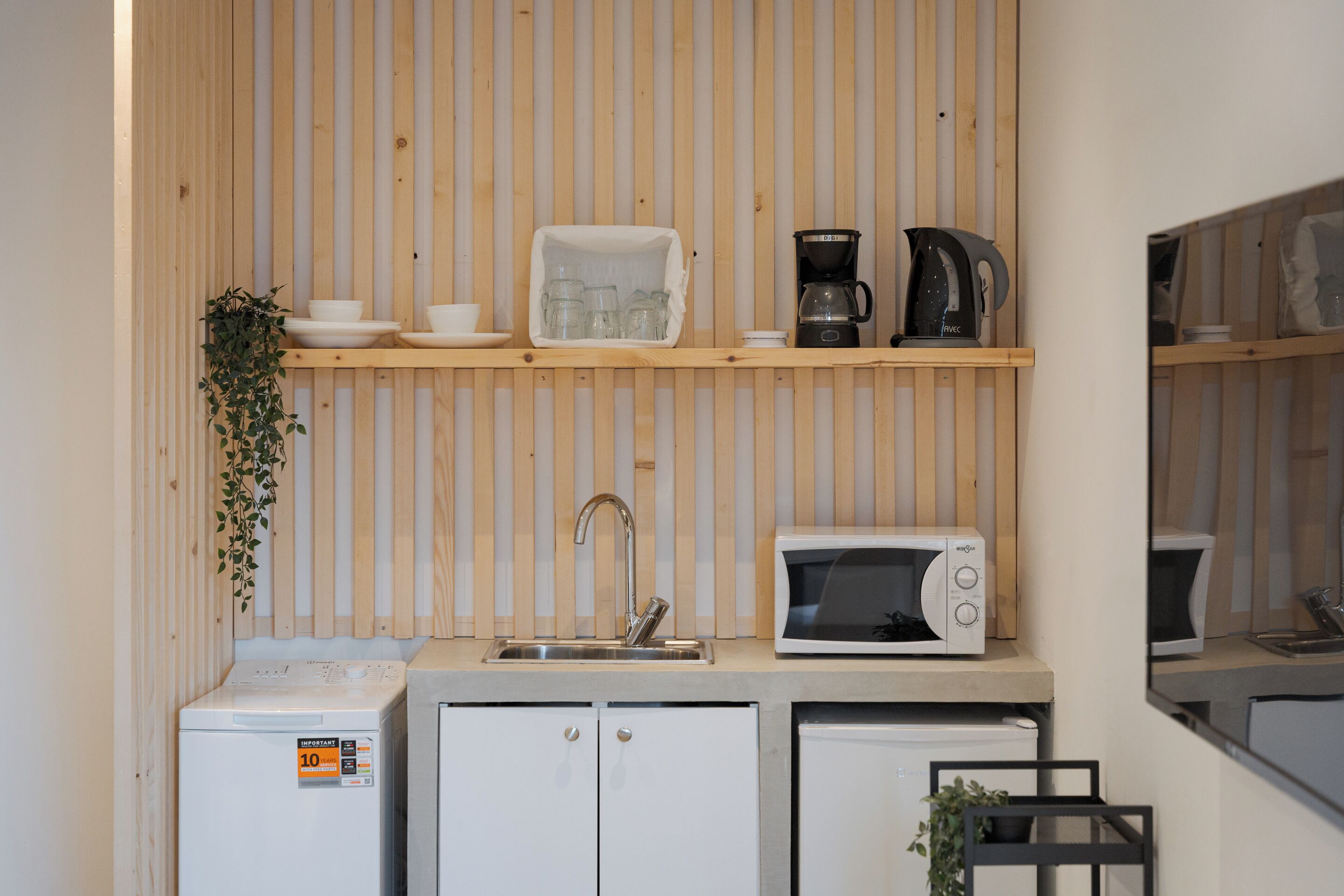 A compact kitchenette with a microwave, coffee maker, and a small refrigerator.