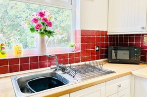 Enjoy cooking in this well-equipped kitchen with a stainless steel sink, microwave, and ample counter space.