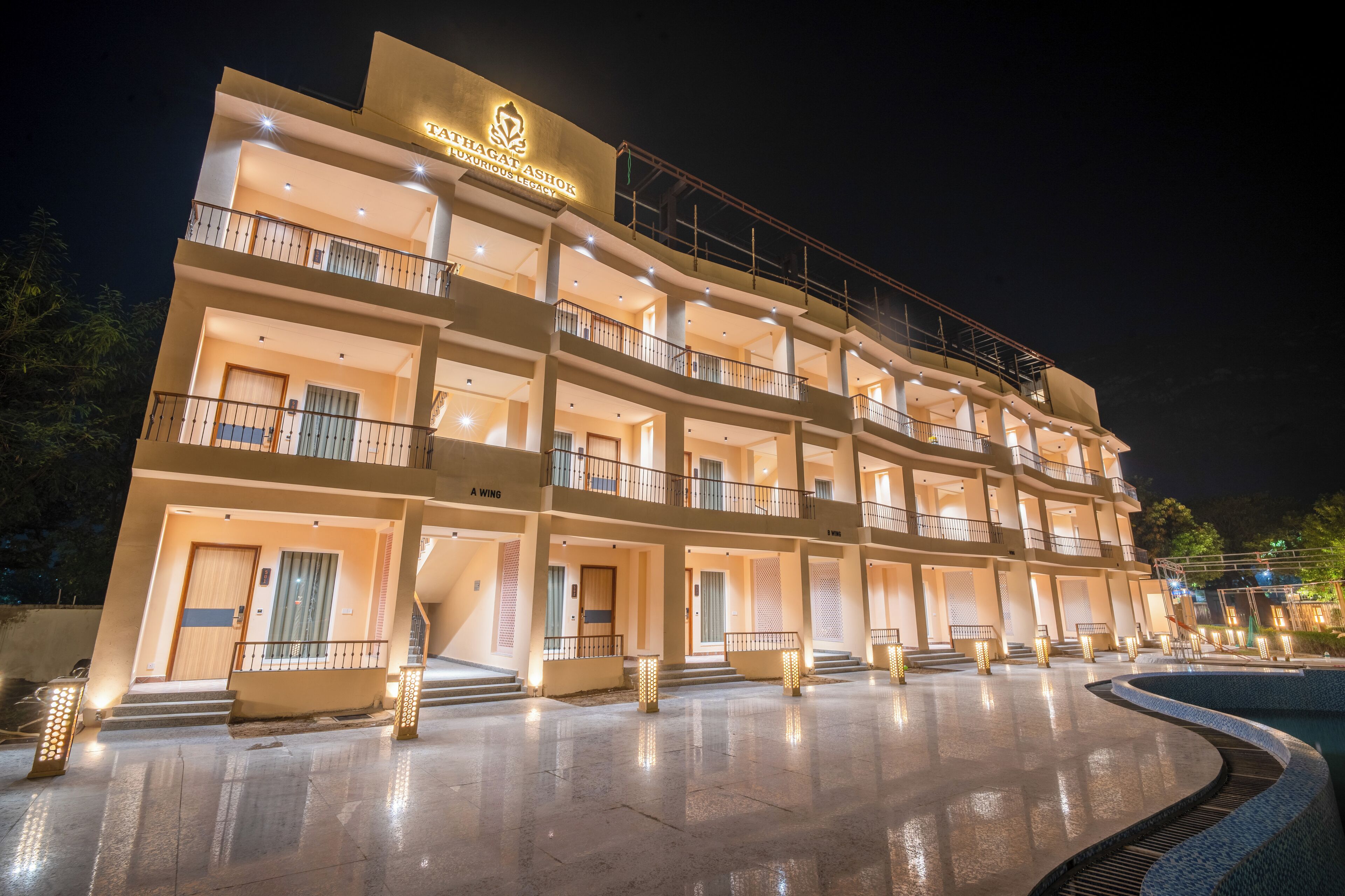 A multi-story hotel with a prominent sign reading "TATHAGAT ASHOK LUXURY RESORT."