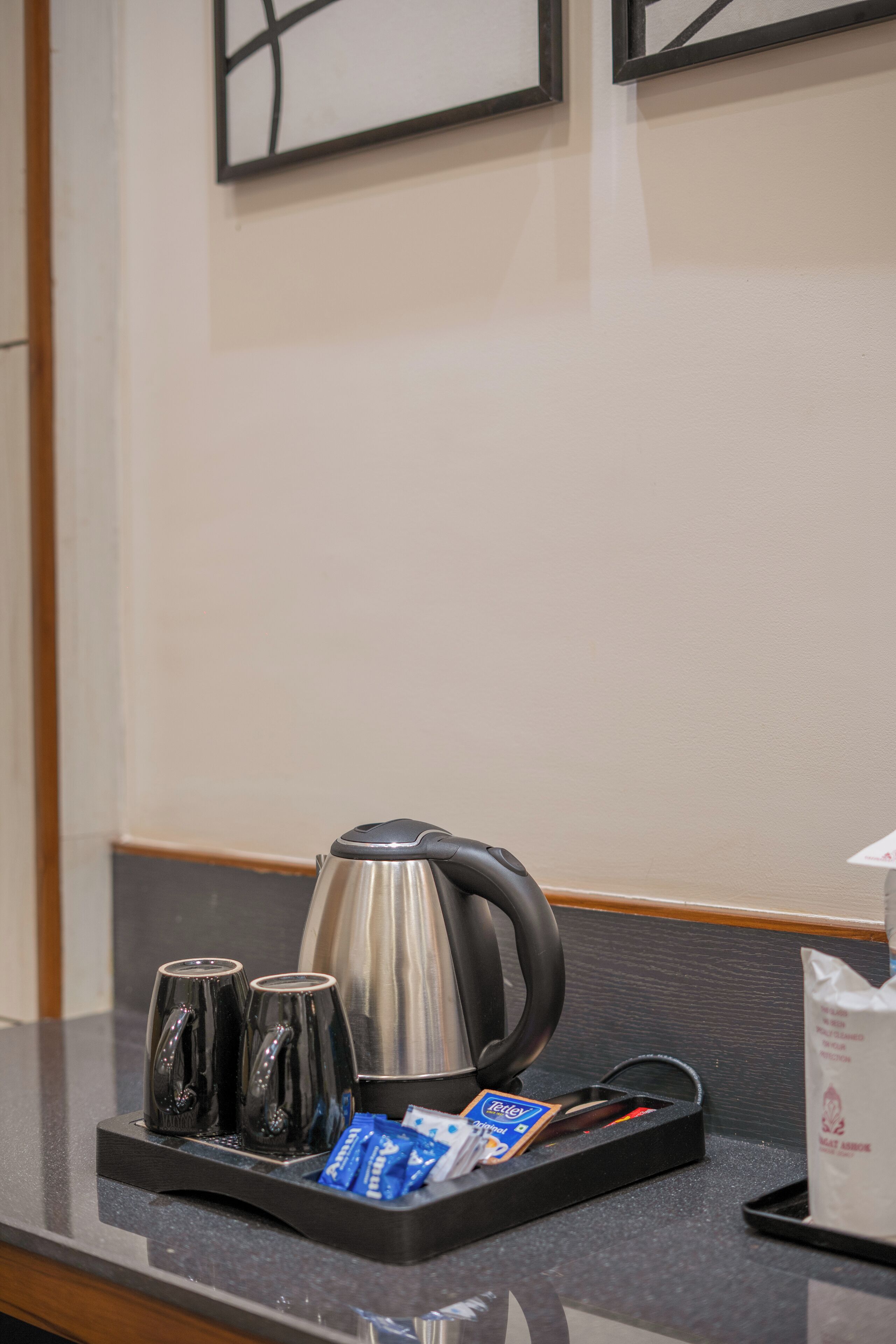 Ein Hotelzimmer mit einer Kaffeestation, inklusive Wasserkocher, zwei Tassen und Kaffeep äckchen.
