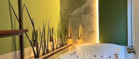 A modern bathroom with a freestanding bathtub, a stone accent wall, and a minimalist design.