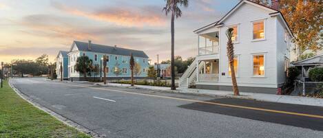 A residential street with houses, a clear sky, and a sunset.