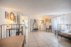 Ein Hotelzimmer mit Bett, Schreibtisch, Stuhl, Treppe und Badezimmer.