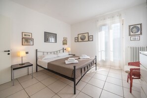 A neatly arranged bedroom with a bed, bedside tables, and wall-mounted pictures.