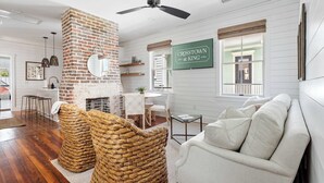 Un salón con chimenea de ladrillo, ventilador de techo y un cartel que dice 'CROSSTOWN at KING'.