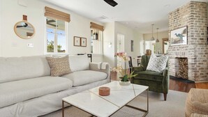 A living room with a sofa, armchair, coffee table, and fireplace. - Downtown 3BR Home - Near King Street! (Charleston)