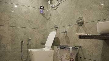 Casa de banho moderna com sanita, bidé e um pequeno banquinho.