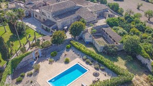 Une grande villa avec piscine, entourée d’une végétation luxuriante et d’un jardin bien entretenu.