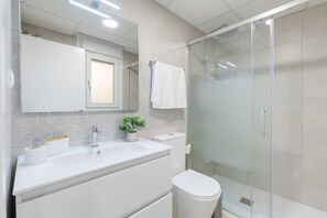 A modern bathroom with a glass shower enclosure, a white sink, and a toilet. - Amazing Between Two Seas by Fidalsa (Murcia)