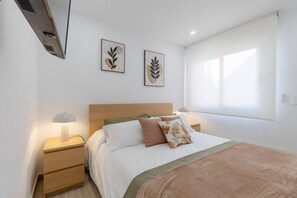 A bedroom with a bed, two bedside tables, a window with curtains, and two wall-mounted artworks. - Amazing Between Two Seas by Fidalsa (Murcia)