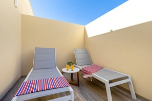 Two lounge chairs with striped cushions, a small round table with two glasses of orange juice, and a red and white striped towel. - Amazing Between Two Seas by Fidalsa (Murcia)