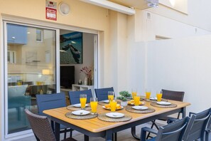 An outdoor dining area with a table set for four, each with a plate, cutlery, and a glass of orange juice. - Amazing Between Two Seas by Fidalsa (Murcia)