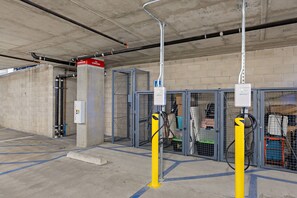 A parking garage with concrete walls, metal gates, and fire extinguishers.