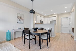 A modern kitchen with white cabinets, a microwave, and a sink.