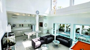 A modern interior with a kitchen, dining area, and poolside seating.