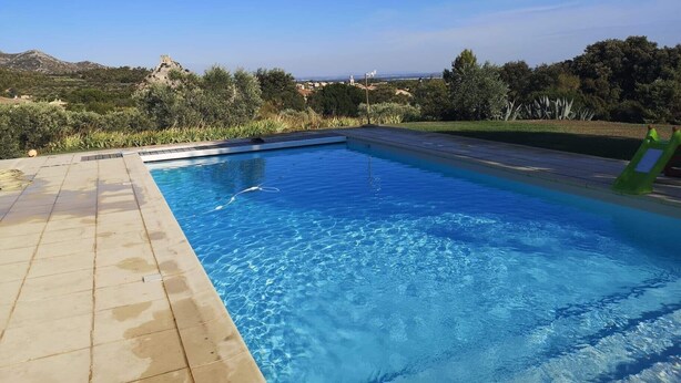 A rectangular swimming pool with clear blue water, surrounded by a tiled deck. - Holiday rental villa view and pool AUREILLE LS1-449 (Aureille)