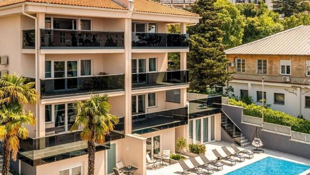 Een meerlaags hotel met een dakzwembad en een terras.