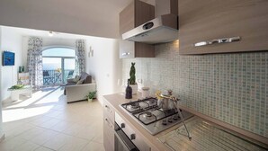 Una cocina moderna con estufa a gas, horno empotrado y salpicadero de azulejos.