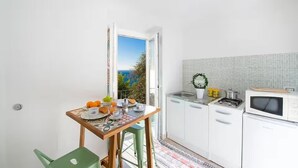 Cocina compacta con comedor, vista por la puerta y una pequeña mesa lista para comer.