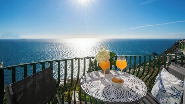 Una terraza con una mesa preparada para dos, con vista al mar.