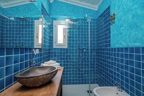 Bathroom features a large round vessel sink, pedestal sink, and walk-in shower with a glass door.