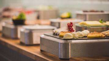 Un buffet proposant une variété de plats, notamment des glaces et des fruits.