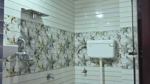 A bathroom with a toilet, sink, and two orange buckets.