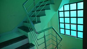A staircase with metal railings and a window with a grid pattern.