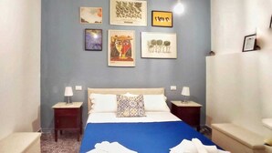 A bedroom with a bed, two bedside tables, a nightstand, and a ceiling with exposed beams. - Palermhost (Palermo)