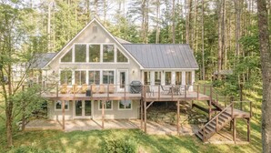 A two-story cabin with a deck, surrounded by a forest. - Family Retreat | 10 Min to Okemo (Ludlow)