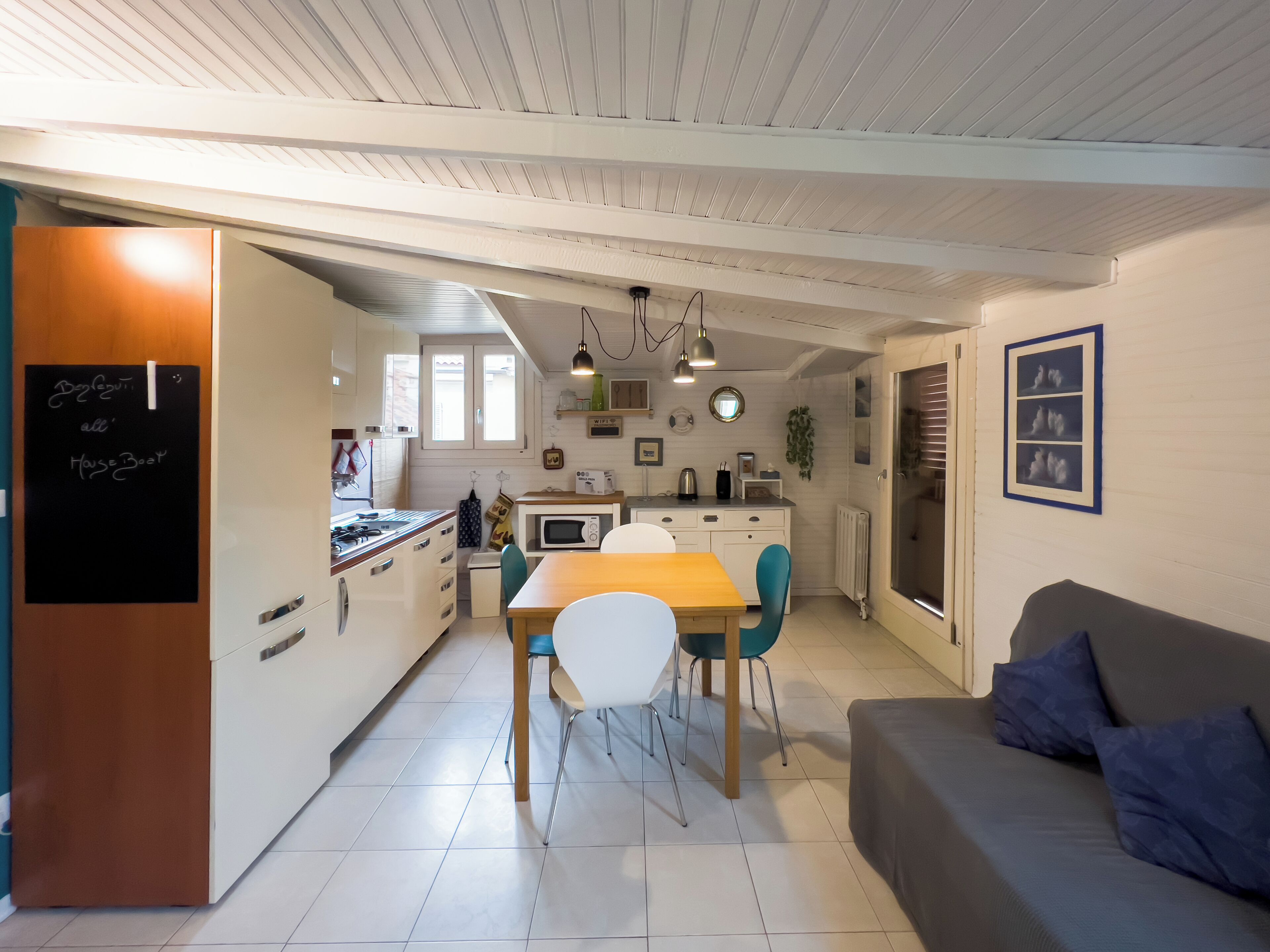 A compact living space with a kitchen, dining area, and a sofa.
