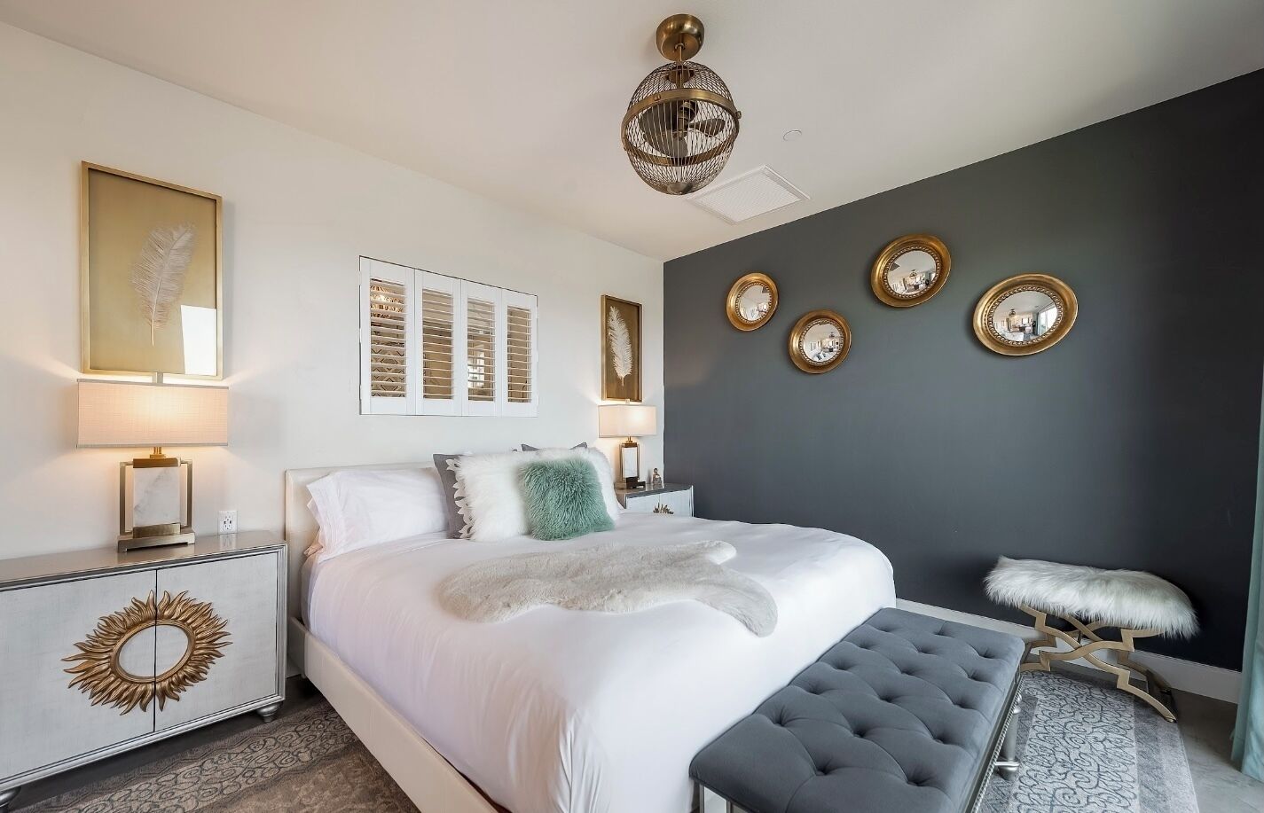 Una camera da letto moderna con un letto grande, comodini, un lampadario e specchi a parete.