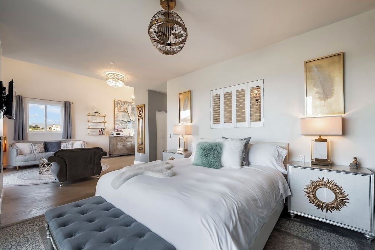 Une chambre moderne avec un grand lit, des lampes de chevet et un miroir décoratif.