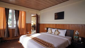 Una camera d'albergo con un letto grande, pannelli di legno, un quadro appeso e una vista dalla finestra.