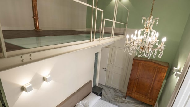 Une chambre à coucher avec un lit superposé, un lustre, une armoire et une petite table de chevet.
