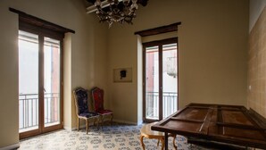 A room with a large wooden table, two chairs, a chandelier, and patterned floor tiles. - Speranzella 2 By Dimorra (NAPOLI)