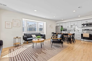 Ein modernes Apartment mit Wohnzimmer, Essbereich und Küche.